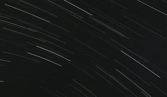 A long exposure of the night sky, creating streaks of star light